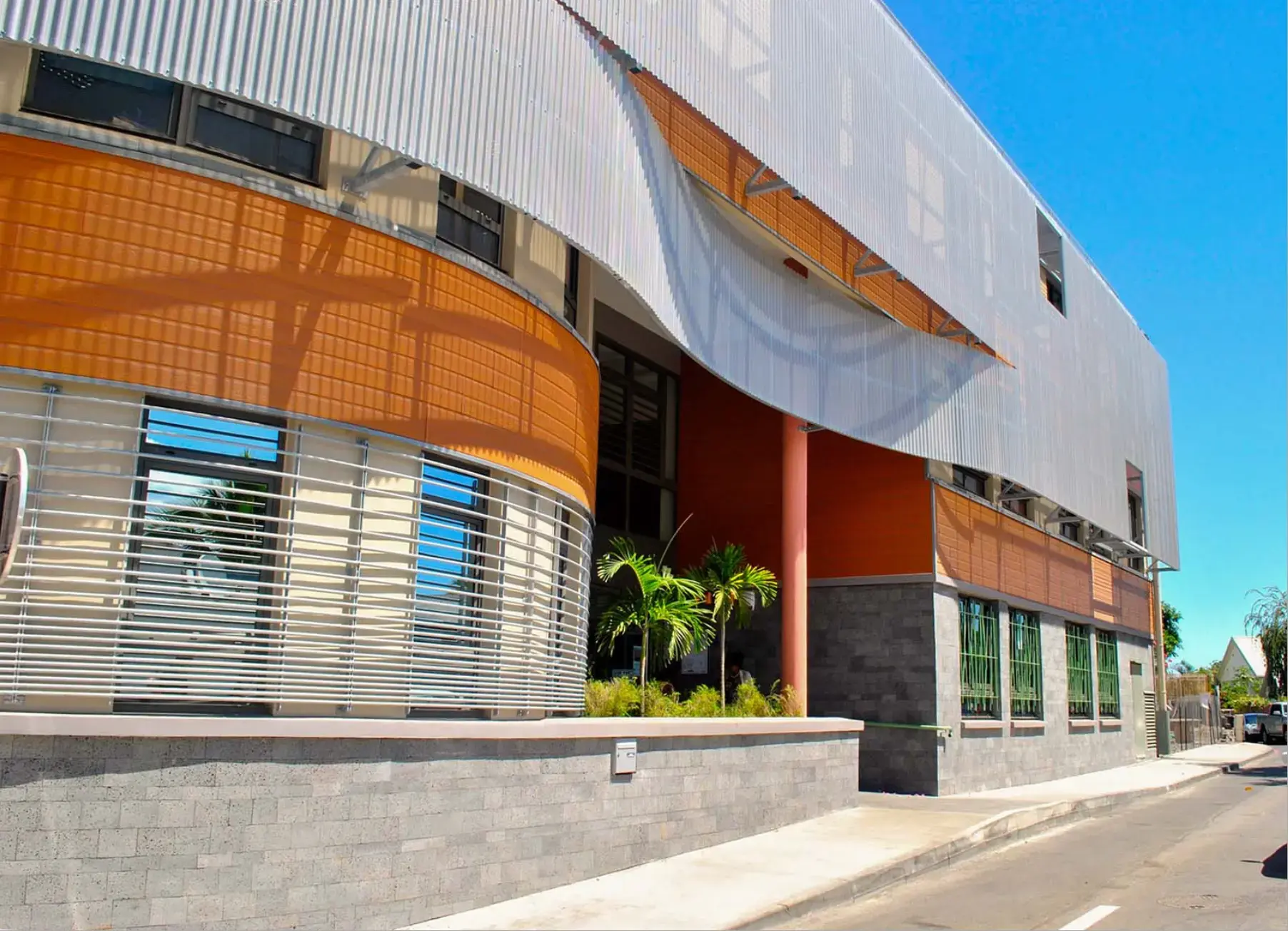 Brise-soleil en lames d'aluminium sur la façade courbe d'un bâtiment public